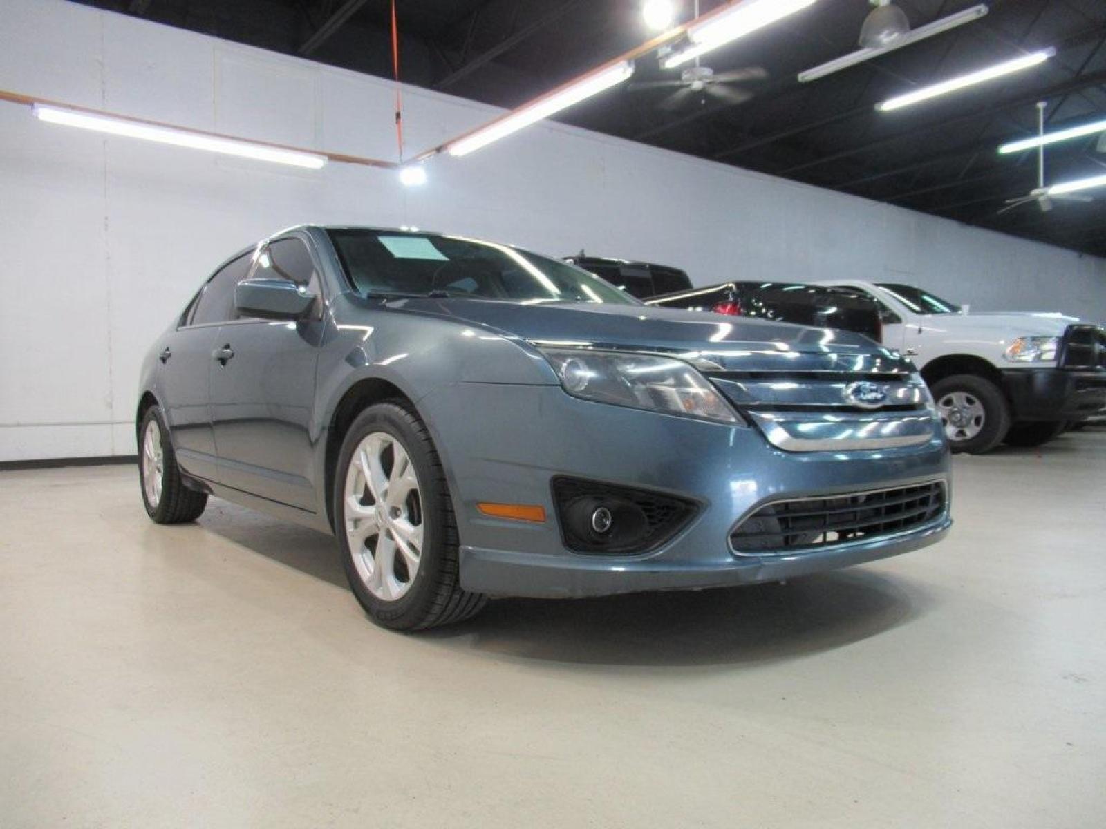 2012 Blue Flame Metallic /Camel Ford Fusion SE (3FAHP0HA5CR) with an 2.5L I4 engine, Automatic transmission, located at 15300 Midway Rd., Addison, 75001, (972) 702-0011, 32.958321, -96.838074 - HOME OF THE NO HAGGLE PRICE - WHOLESALE PRICES TO THE PUBLIC!! Fusion SE, 4D Sedan, 2.5L I4, 6-Speed Automatic, FWD, Blue Flame Metallic, Camel Cloth. Priced below KBB Fair Purchase Price!<br><br>Blue Flame Metallic 2012 Ford Fusion SE<br><br>23/33 City/Highway MPG<br><br>Awards:<br> * 2012 IIHS To - Photo #1