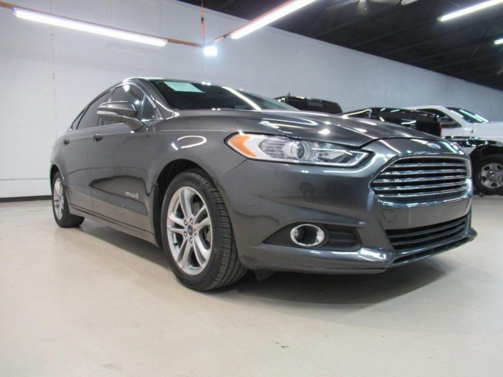 2016 Gray /Earth Gray Ford Fusion Hybrid SE (3FA6P0LU9GR) with an I4 Hybrid engine, CVT transmission, located at 15300 Midway Rd., Addison, 75001, (972) 702-0011, 32.958321, -96.838074 - HOME OF THE NO HAGGLE PRICE - WHOLESALE PRICES TO THE PUBLIC!! Fusion Hybrid SE, 4D Sedan, I4 Hybrid, E-CVT Automatic, FWD, Gray, Earth Gray Cloth.<br><br>Gray 2016 Ford Fusion Hybrid SE<br><br>44/41 City/Highway MPG<br><br>Awards:<br> * 2016 KBB.com 10 Best Sedans Under $25,000 * 2016 KBB.com Br - Photo #1