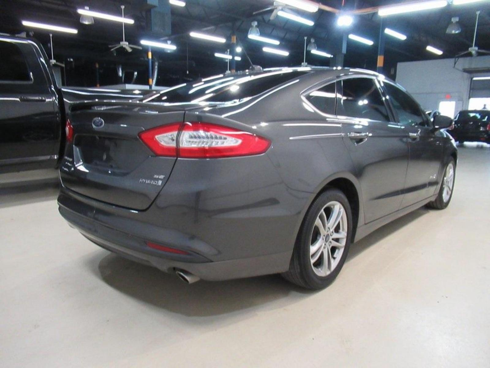 2016 Gray /Earth Gray Ford Fusion Hybrid SE (3FA6P0LU9GR) with an I4 Hybrid engine, CVT transmission, located at 15300 Midway Rd., Addison, 75001, (972) 702-0011, 32.958321, -96.838074 - HOME OF THE NO HAGGLE PRICE - WHOLESALE PRICES TO THE PUBLIC!! Fusion Hybrid SE, 4D Sedan, I4 Hybrid, E-CVT Automatic, FWD, Gray, Earth Gray Cloth.<br><br>Gray 2016 Ford Fusion Hybrid SE<br><br>44/41 City/Highway MPG<br><br>Awards:<br> * 2016 KBB.com 10 Best Sedans Under $25,000 * 2016 KBB.com Br - Photo #2