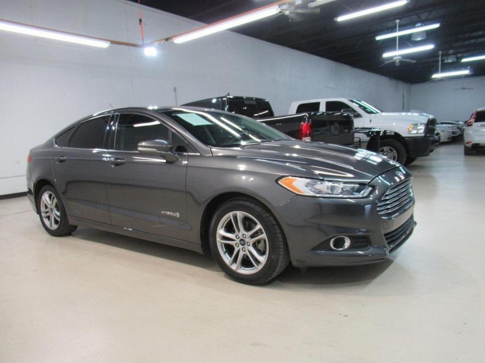 2016 Gray /Earth Gray Ford Fusion Hybrid SE (3FA6P0LU9GR) with an I4 Hybrid engine, CVT transmission, located at 15300 Midway Rd., Addison, 75001, (972) 702-0011, 32.958321, -96.838074 - HOME OF THE NO HAGGLE PRICE - WHOLESALE PRICES TO THE PUBLIC!! Fusion Hybrid SE, 4D Sedan, I4 Hybrid, E-CVT Automatic, FWD, Gray, Earth Gray Cloth.<br><br>Gray 2016 Ford Fusion Hybrid SE<br><br>44/41 City/Highway MPG<br><br>Awards:<br> * 2016 KBB.com 10 Best Sedans Under $25,000 * 2016 KBB.com Br - Photo #4