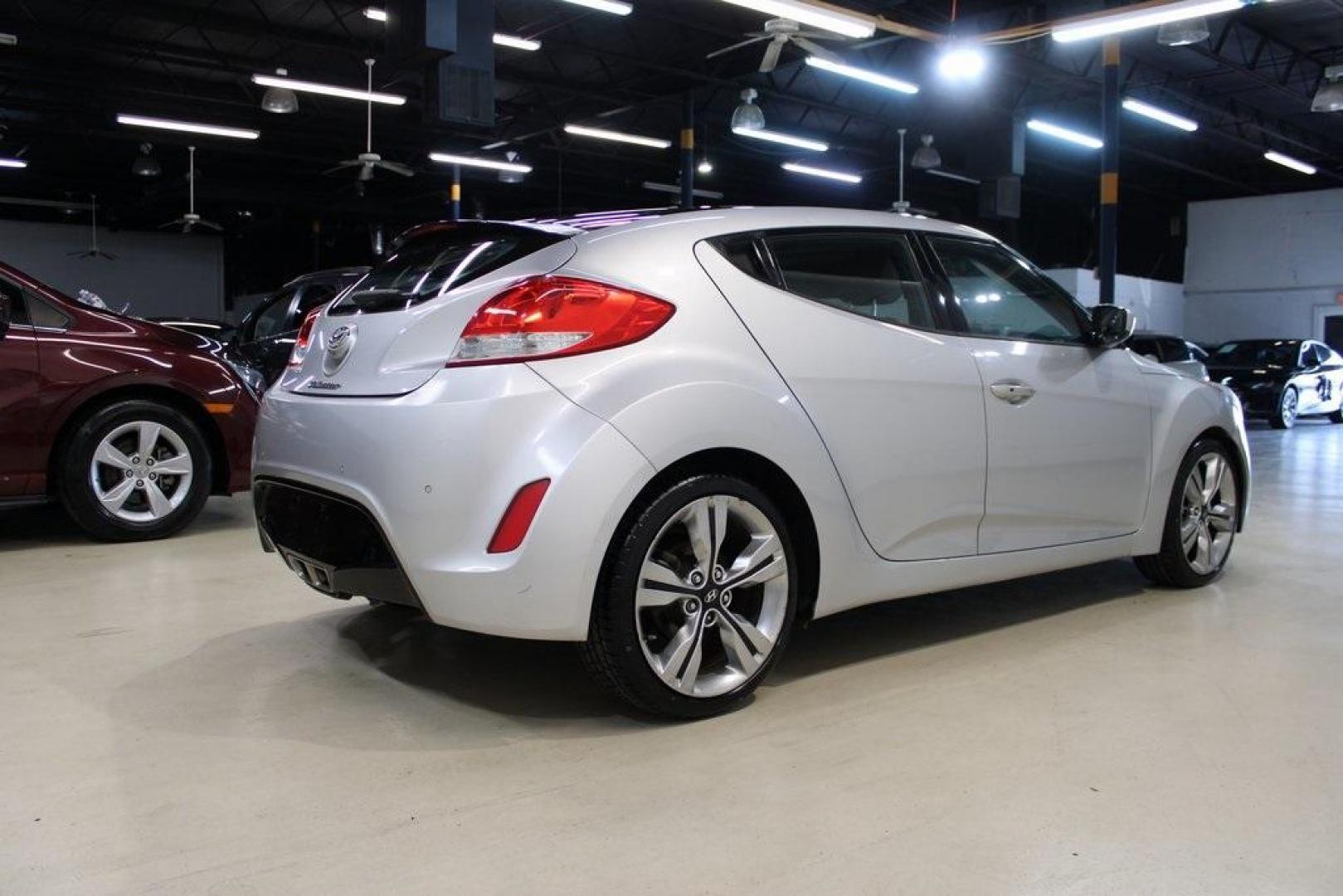 2012 Ironman Silver /Gray Hyundai Veloster Base (KMHTC6AD0CU) with an 1.6L 4-Cylinder DGI DOHC engine, Automatic transmission, located at 15300 Midway Rd., Addison, TX, 75001, (972) 702-0011, 32.958321, -96.838074 - HOME OF THE NO HAGGLE PRICE - WHOLESALE PRICES TO THE PUBLIC!! 3D Hatchback, 1.6L 4-Cylinder DGI DOHC, 6-Speed Automatic, FWD, Ironman Silver, Gray Cloth.<br><br>Ironman Silver 2012 Hyundai Veloster<br><br>27/35 City/Highway MPG<br><br>Awards:<br> * 2012 KBB.com 10 Coolest New Cars Under $18,000<br - Photo#2