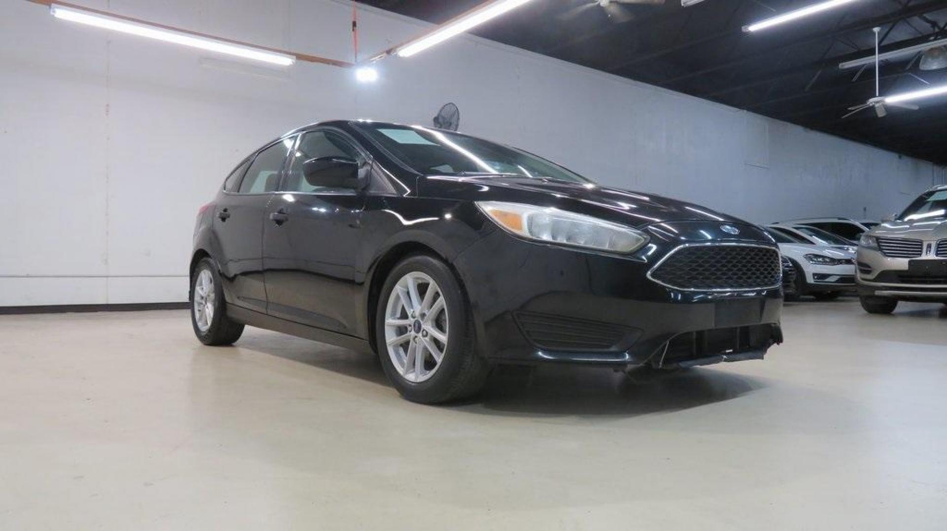 2018 Shadow Black /Charcoal Black Ford Focus SE (1FADP3K28JL) with an 2.0L I4 DGI Ti-VCT engine, Automatic transmission, located at 15300 Midway Rd., Addison, TX, 75001, (972) 702-0011, 32.958321, -96.838074 - 2018 Ford Focus SE Hatchback<br>Now Available at Midway Auto Group Addison, Texas<br><br>The 2018 Ford Focus SE Hatchback combines practicality, efficiency, and style, making it the ideal choice for daily commutes and weekend getaways alike. With its sporty handling, comfortable interior, and advan - Photo#1
