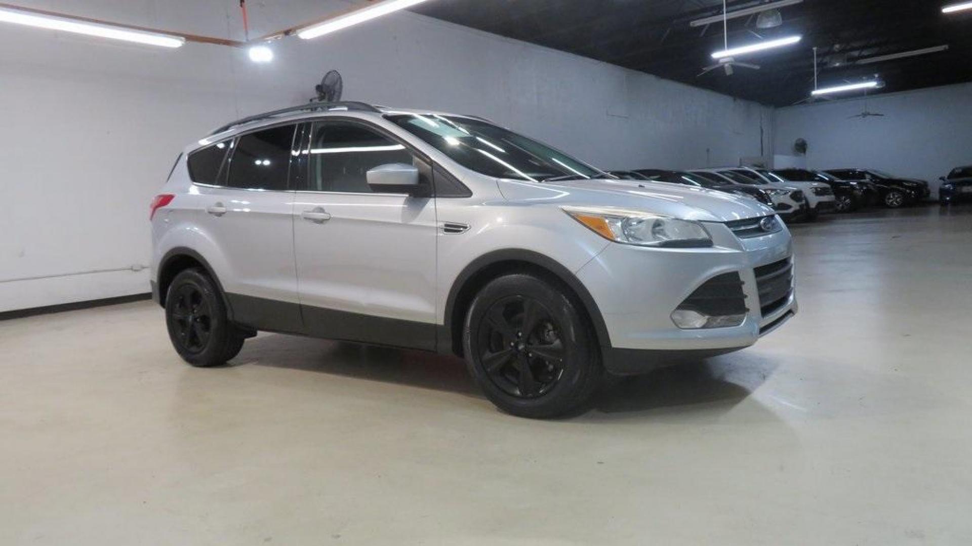 2014 Ingot Silver /Black Ford Escape SE (1FMCU0GX0EU) with an EcoBoost 1.6L I4 GTDi DOHC Turbocharged VCT engine, Automatic transmission, located at 15300 Midway Rd., Addison, TX, 75001, (972) 702-0011, 32.958321, -96.838074 - 2014 Ford Escape SE<br>Now Available at Midway Auto Group Addison, Texas<br><br>Versatile, efficient, and packed with comfort, the 2014 Ford Escape SE is a smart choice for drivers who need capability without sacrificing style. Whether you're commuting through Addison or embarking on weekend getawa - Photo#7