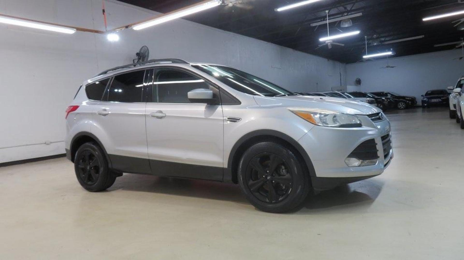 2014 Ingot Silver /Black Ford Escape SE (1FMCU0GX0EU) with an EcoBoost 1.6L I4 GTDi DOHC Turbocharged VCT engine, Automatic transmission, located at 15300 Midway Rd., Addison, TX, 75001, (972) 702-0011, 32.958321, -96.838074 - 2014 Ford Escape SE<br>Now Available at Midway Auto Group Addison, Texas<br><br>Versatile, efficient, and packed with comfort, the 2014 Ford Escape SE is a smart choice for drivers who need capability without sacrificing style. Whether you're commuting through Addison or embarking on weekend getawa - Photo#8