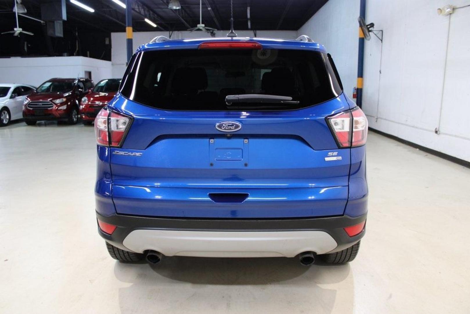 2018 Lightning Blue /Charcoal Black Ford Escape SE (1FMCU9GD6JU) with an EcoBoost 2.0L I4 GTDi DOHC Turbocharged VCT engine, Automatic transmission, located at 15300 Midway Rd., Addison, TX, 75001, (972) 702-0011, 32.958321, -96.838074 - 2018 Ford Escape SE<br>Now Available at Midway Auto Group Addison, Texas<br><br>Stylish, versatile, and packed with features, the 2018 Ford Escape SE offers a confident driving experience thats perfect for both urban commutes and weekend getaways. With its turbocharged performance, smart technology - Photo#7