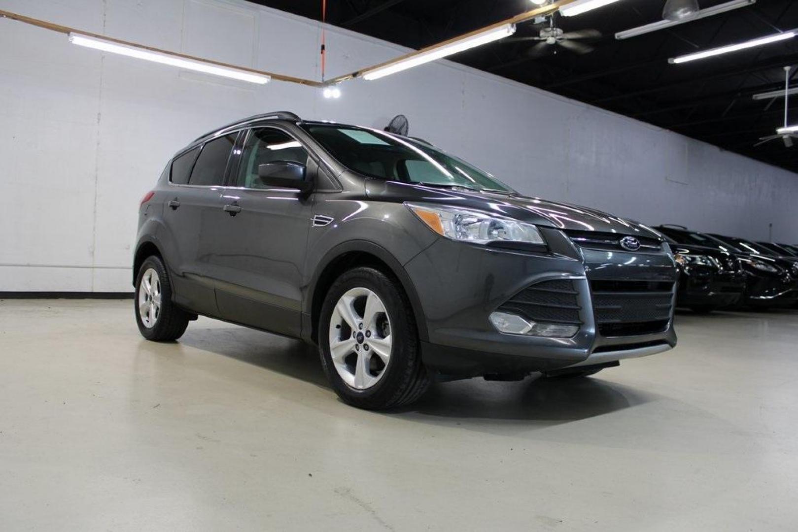 2015 Magnetic /Medium Light Stone Ford Escape SE (1FMCU0GXXFU) with an EcoBoost 1.6L I4 GTDi DOHC Turbocharged VCT engine, Automatic transmission, located at 15300 Midway Rd., Addison, TX, 75001, (972) 702-0011, 32.958321, -96.838074 - 2015 Ford Escape SE<br>Now Available at Midway Auto Group Addison, Texas<br><br>Sporty, practical, and fuel-efficient, the 2015 Ford Escape SE offers everything you want in a compact SUVresponsive handling, flexible cargo space, and modern technology. Whether you're navigating daily errands in Addi - Photo#1