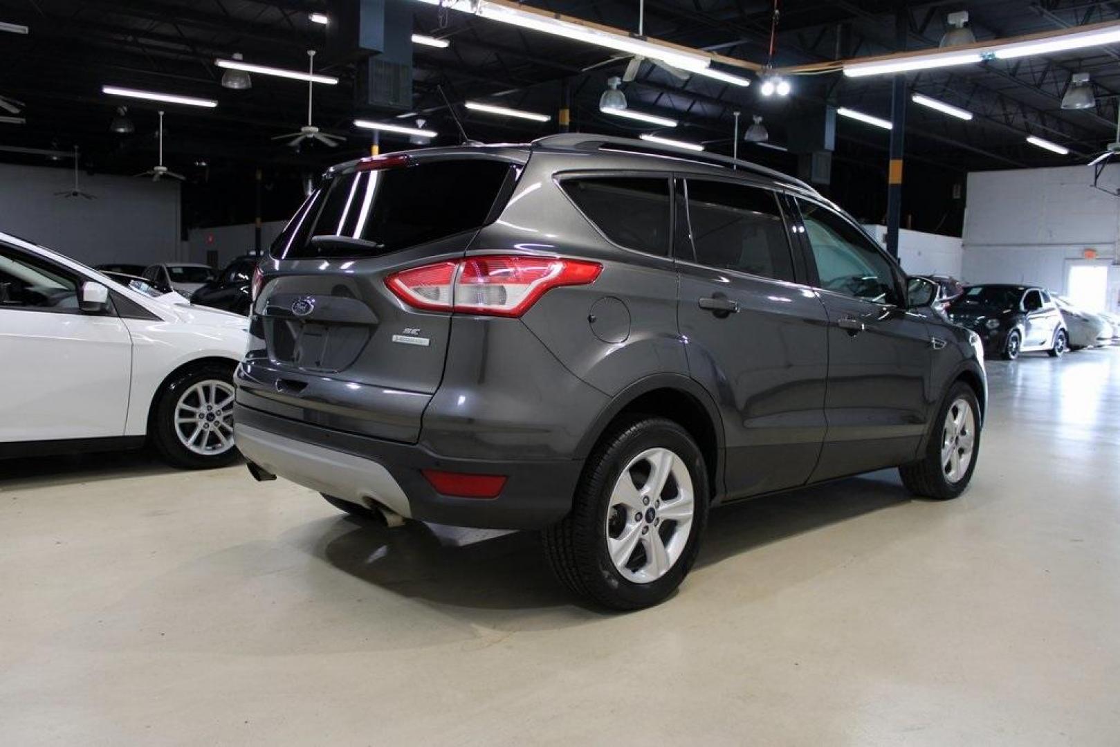 2015 Magnetic /Medium Light Stone Ford Escape SE (1FMCU0GXXFU) with an EcoBoost 1.6L I4 GTDi DOHC Turbocharged VCT engine, Automatic transmission, located at 15300 Midway Rd., Addison, TX, 75001, (972) 702-0011, 32.958321, -96.838074 - 2015 Ford Escape SE<br>Now Available at Midway Auto Group Addison, Texas<br><br>Sporty, practical, and fuel-efficient, the 2015 Ford Escape SE offers everything you want in a compact SUVresponsive handling, flexible cargo space, and modern technology. Whether you're navigating daily errands in Addi - Photo#2