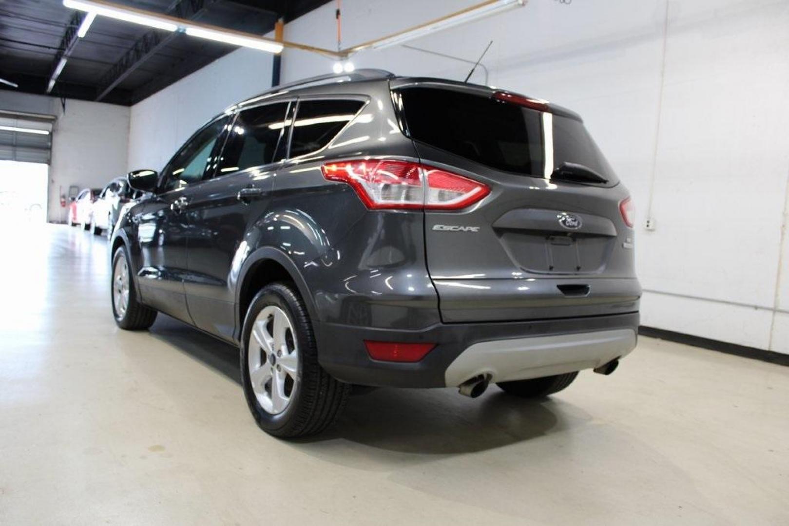 2015 Magnetic /Medium Light Stone Ford Escape SE (1FMCU0GXXFU) with an EcoBoost 1.6L I4 GTDi DOHC Turbocharged VCT engine, Automatic transmission, located at 15300 Midway Rd., Addison, TX, 75001, (972) 702-0011, 32.958321, -96.838074 - 2015 Ford Escape SE<br>Now Available at Midway Auto Group Addison, Texas<br><br>Sporty, practical, and fuel-efficient, the 2015 Ford Escape SE offers everything you want in a compact SUVresponsive handling, flexible cargo space, and modern technology. Whether you're navigating daily errands in Addi - Photo#3