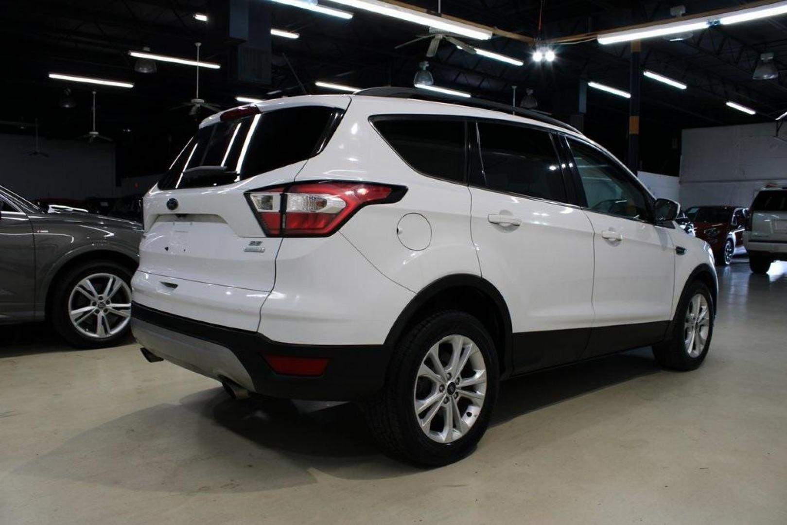 2018 Oxford White /Medium Light Stone Ford Escape SE (1FMCU0G99JU) with an EcoBoost 1.5L I4 GTDi DOHC Turbocharged VCT engine, Automatic transmission, located at 15300 Midway Rd., Addison, TX, 75001, (972) 702-0011, 32.958321, -96.838074 - 2018 Ford Escape SE<br>Now Available at Midway Auto Group Addison, Texas<br><br>The 2018 Ford Escape SE blends sporty style with everyday practicality, making it a top pick for drivers who want comfort, technology, and versatility in a compact SUV. With a turbocharged engine, spacious interior, and - Photo#2