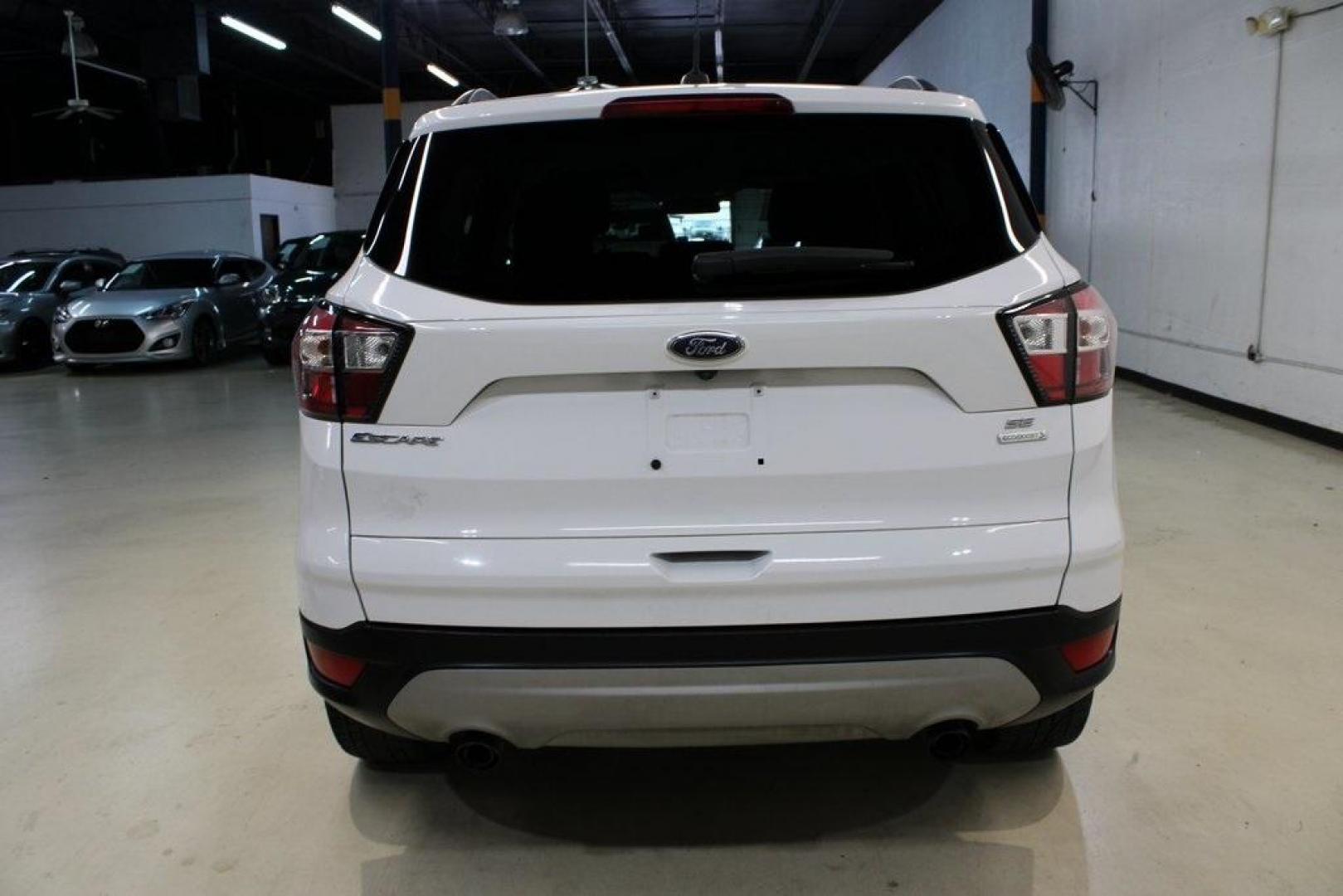 2018 Oxford White /Medium Light Stone Ford Escape SE (1FMCU0G99JU) with an EcoBoost 1.5L I4 GTDi DOHC Turbocharged VCT engine, Automatic transmission, located at 15300 Midway Rd., Addison, TX, 75001, (972) 702-0011, 32.958321, -96.838074 - 2018 Ford Escape SE<br>Now Available at Midway Auto Group Addison, Texas<br><br>The 2018 Ford Escape SE blends sporty style with everyday practicality, making it a top pick for drivers who want comfort, technology, and versatility in a compact SUV. With a turbocharged engine, spacious interior, and - Photo#7