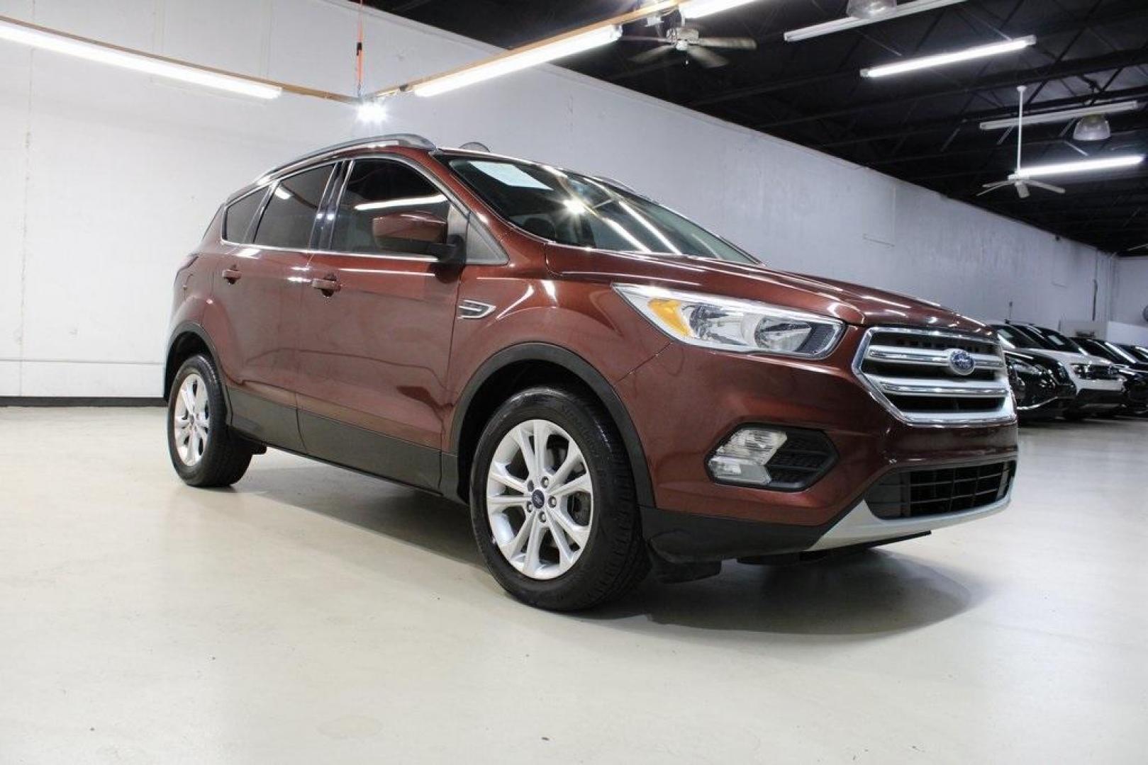 2018 Cinnamon Glaze /Charcoal Black Ford Escape SE (1FMCU0GD6JU) with an EcoBoost 2.0L I4 GTDi DOHC Turbocharged VCT engine, Automatic transmission, located at 15300 Midway Rd., Addison, TX, 75001, (972) 702-0011, 32.958321, -96.838074 - HOME OF THE NO HAGGLE PRICE - WHOLESALE PRICES TO THE PUBLIC!!<br><br>Cinnamon Glaze 2018 Ford Escape SE<br><br>23/30 City/Highway MPG<br><br>Awards:<br> * 2018 KBB.com 10 Most Awarded Brands * 2018 KBB.com Brand Image Awards<br><br>At Midway Auto Group, we strive to provide you with the best qua - Photo#1