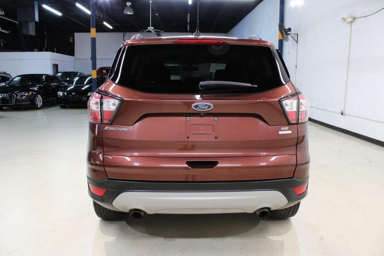 2018 Cinnamon Glaze /Charcoal Black Ford Escape SE (1FMCU0GD6JU) with an EcoBoost 2.0L I4 GTDi DOHC Turbocharged VCT engine, Automatic transmission, located at 15300 Midway Rd., Addison, TX, 75001, (972) 702-0011, 32.958321, -96.838074 - HOME OF THE NO HAGGLE PRICE - WHOLESALE PRICES TO THE PUBLIC!!<br><br>Cinnamon Glaze 2018 Ford Escape SE<br><br>23/30 City/Highway MPG<br><br>Awards:<br> * 2018 KBB.com 10 Most Awarded Brands * 2018 KBB.com Brand Image Awards<br><br>At Midway Auto Group, we strive to provide you with the best qua - Photo#7
