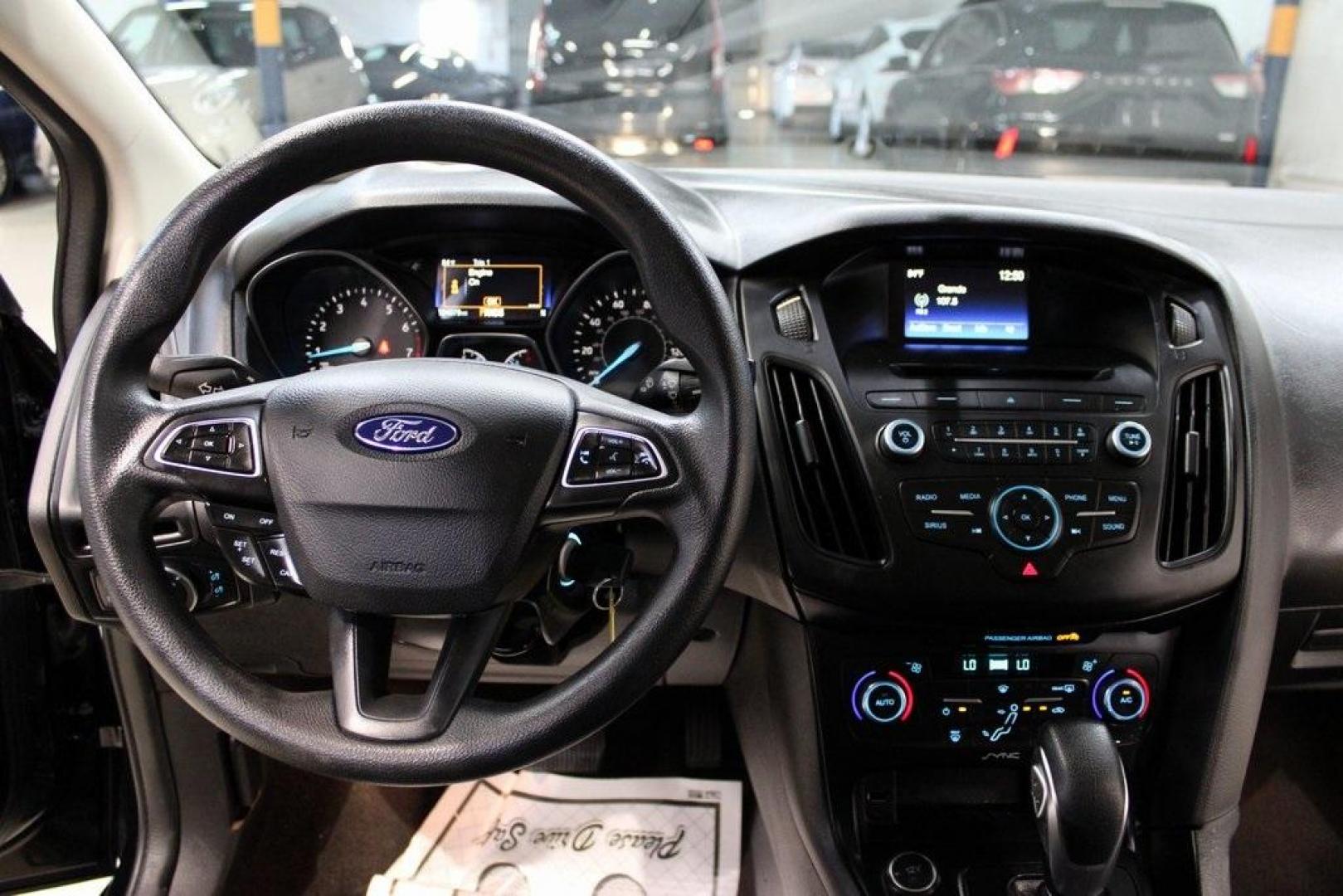 2017 Shadow Black /Charcoal Black Ford Focus SE (1FADP3FE8HL) with an EcoBoost 1.0L I3 GTDi DOHC Turbocharged VCT engine, Automatic transmission, located at 15300 Midway Rd., Addison, TX, 75001, (972) 702-0011, 32.958321, -96.838074 - HOME OF THE NO HAGGLE PRICE - WHOLESALE PRICES TO THE PUBLIC!!<br><br>Shadow Black 2017 Ford Focus SE<br><br>Recent Arrival! 27/38 City/Highway MPG<br><br>Awards:<br> * 2017 KBB.com 10 Most Awarded Brands * 2017 KBB.com Brand Image Awards<br><br>At Midway Auto Group, we strive to provide you with - Photo#16