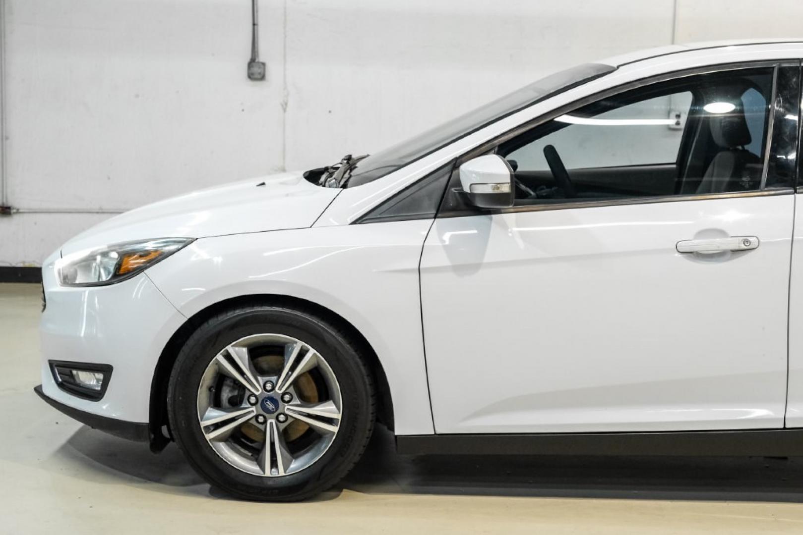2017 Oxford White /Medium Light Stone Ford Focus SE (1FADP3FE0HL) with an EcoBoost 1.0L I3 GTDi DOHC Turbocharged VCT engine, Automatic transmission, located at 15300 Midway Rd., Addison, TX, 75001, (972) 702-0011, 32.958321, -96.838074- Photo#11