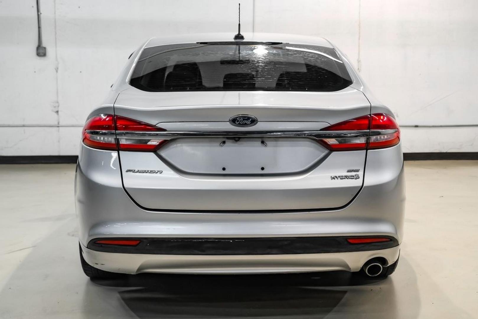 2017 Ingot Silver /Medium Light Stone Ford Fusion Hybrid SE (3FA6P0LU3HR) with an I4 Hybrid engine, CVT transmission, located at 15300 Midway Rd., Addison, TX, 75001, (972) 702-0011, 32.958321, -96.838074- Photo#7
