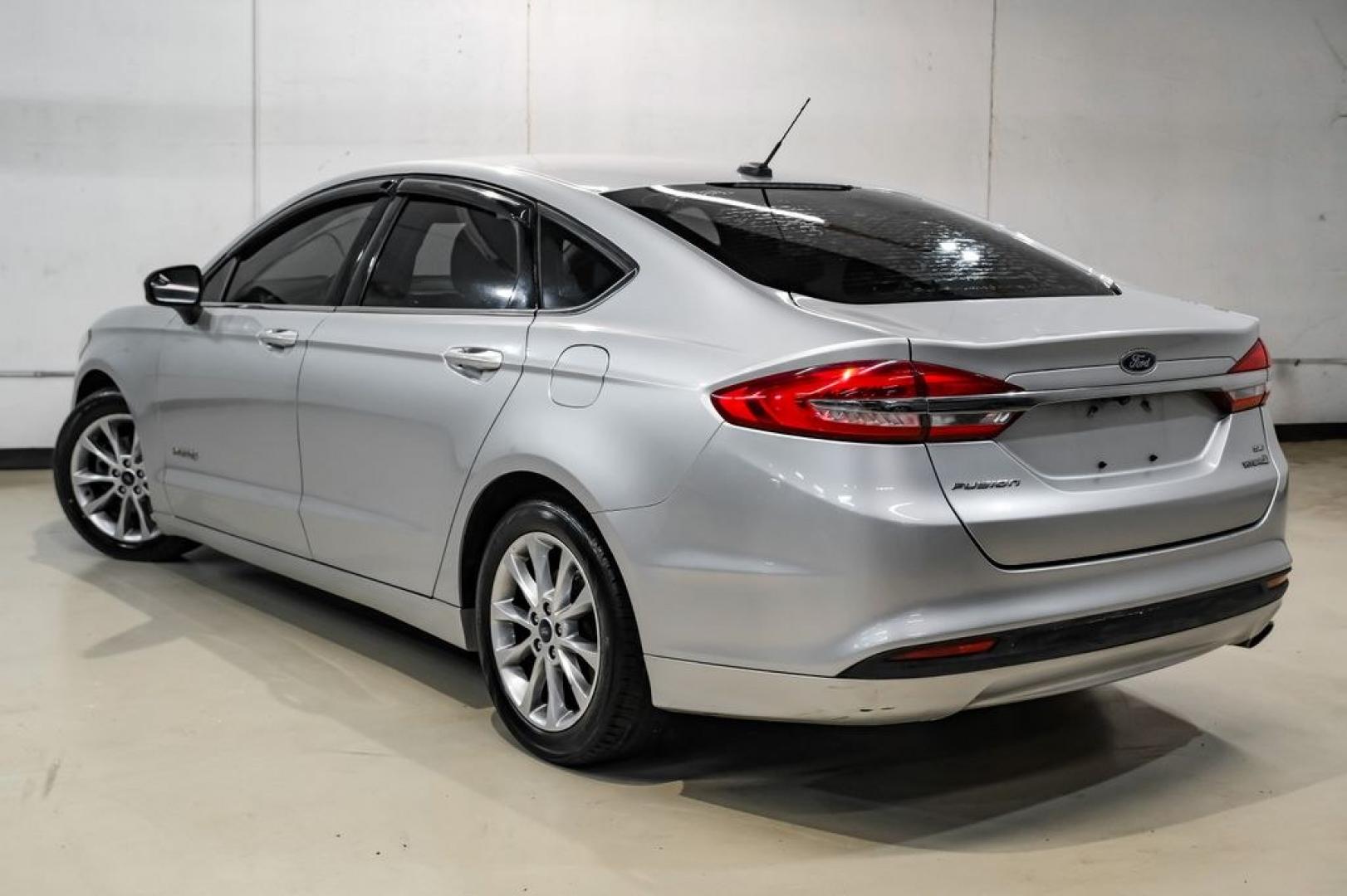 2017 Ingot Silver /Medium Light Stone Ford Fusion Hybrid SE (3FA6P0LU3HR) with an I4 Hybrid engine, CVT transmission, located at 15300 Midway Rd., Addison, TX, 75001, (972) 702-0011, 32.958321, -96.838074- Photo#8