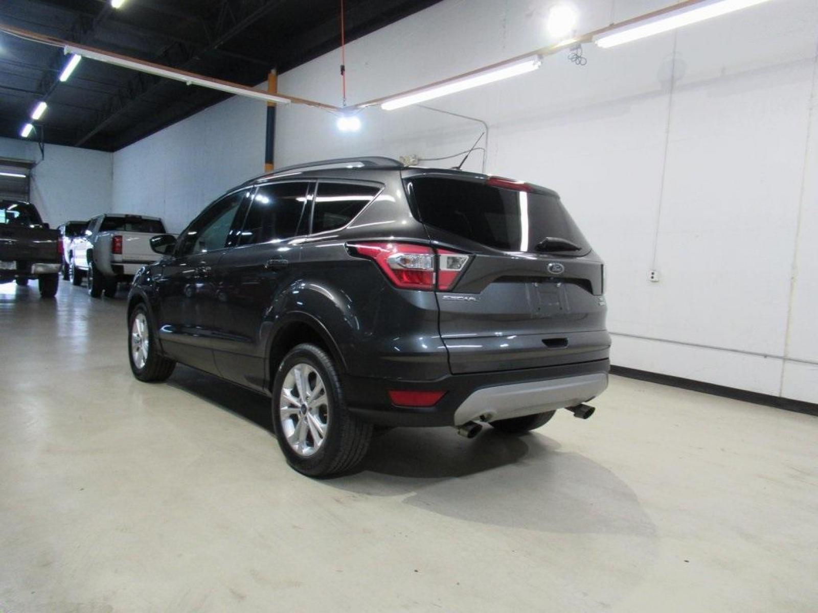 2018 Magnetic /Medium Light Stone Ford Escape SE (1FMCU0GD7JU) with an EcoBoost 1.5L I4 GTDi DOHC Turbocharged VCT engine, Automatic transmission, located at 15300 Midway Rd., Addison, 75001, (972) 702-0011, 32.958321, -96.838074 - HOME OF THE NO HAGGLE PRICE - WHOLESALE PRICES TO THE PUBLIC!! Escape SE, 4D Sport Utility, EcoBoost 1.5L I4 GTDi DOHC Turbocharged VCT, 6-Speed Automatic, FWD, Magnetic, Medium Light Stone Cloth. Odometer is 18027 miles below market average!<br><br>Magnetic 2018 Ford Escape SE<br><br>23/30 City/Hig - Photo #3