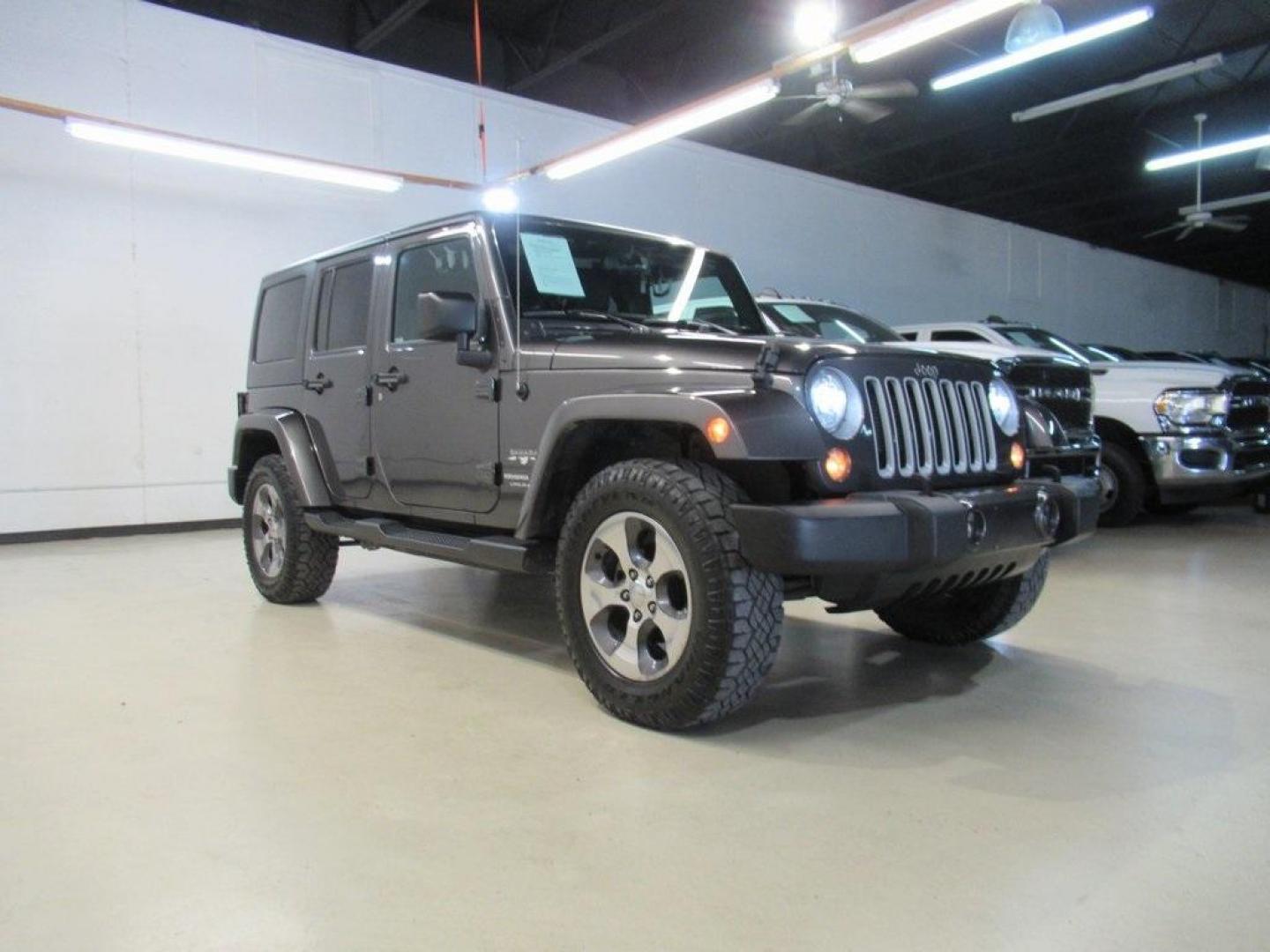 2018 Granite Crystal Metallic Clearcoat /Black Jeep Wrangler JK Unlimited Sahara (1C4BJWEG0JL) with an 3.6L V6 24V VVT engine, Automatic transmission, located at 15300 Midway Rd., Addison, TX, 75001, (972) 702-0011, 32.958321, -96.838074 - HOME OF THE NO HAGGLE PRICE - WHOLESALE PRICES TO THE PUBLIC!! Wrangler JK Unlimited Sahara, 4D Sport Utility, 3.6L V6 24V VVT, 5-Speed Automatic, 4WD, Granite Crystal Metallic Clearcoat, Black Cloth.<br><br>Granite Crystal Metallic Clearcoat 2018 Jeep Wrangler JK Unlimited Sahara<br><br>Recent Arri - Photo#1
