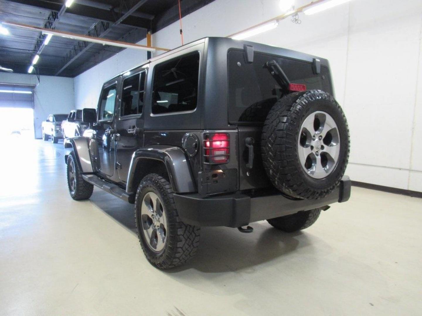 2018 Granite Crystal Metallic Clearcoat /Black Jeep Wrangler JK Unlimited Sahara (1C4BJWEG0JL) with an 3.6L V6 24V VVT engine, Automatic transmission, located at 15300 Midway Rd., Addison, TX, 75001, (972) 702-0011, 32.958321, -96.838074 - HOME OF THE NO HAGGLE PRICE - WHOLESALE PRICES TO THE PUBLIC!! Wrangler JK Unlimited Sahara, 4D Sport Utility, 3.6L V6 24V VVT, 5-Speed Automatic, 4WD, Granite Crystal Metallic Clearcoat, Black Cloth.<br><br>Granite Crystal Metallic Clearcoat 2018 Jeep Wrangler JK Unlimited Sahara<br><br>Recent Arri - Photo#2