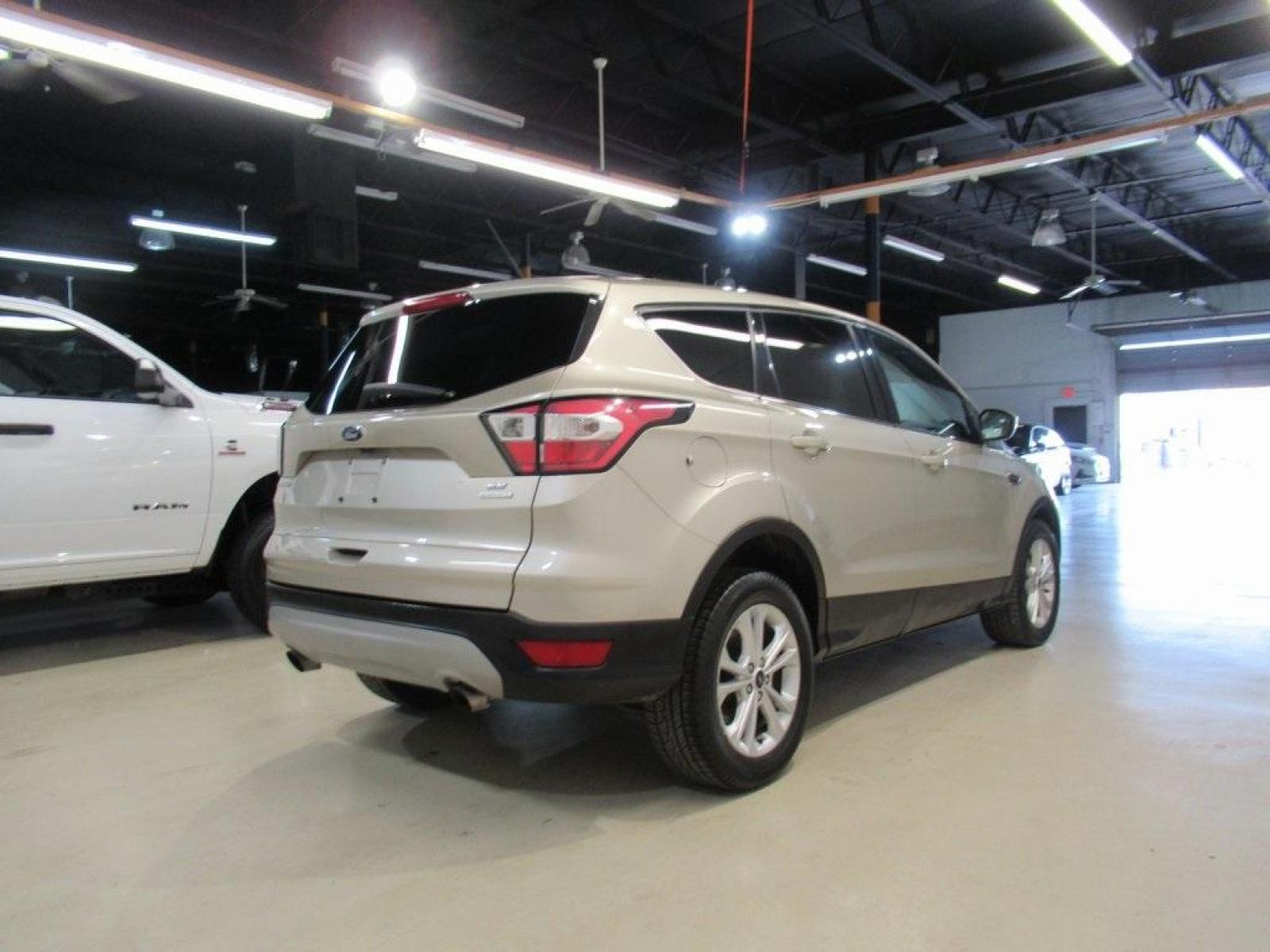 2017 White Gold Metallic /Charcoal Black Ford Escape SE (1FMCU0G94HU) with an EcoBoost 2.0L I4 GTDi DOHC Turbocharged VCT engine, Automatic transmission, located at 15300 Midway Rd., Addison, 75001, (972) 702-0011, 32.958321, -96.838074 - HOME OF THE NO HAGGLE PRICE - WHOLESALE PRICES TO THE PUBLIC!! Escape SE, 4D Sport Utility, EcoBoost 2.0L I4 GTDi DOHC Turbocharged VCT, 6-Speed Automatic, FWD, Gold, Charcoal Black Cloth.<br><br>Gold 2017 Ford Escape SE<br><br>Recent Arrival! 22/29 City/Highway MPG<br><br>Awards:<br> * 2017 KBB.co - Photo #2