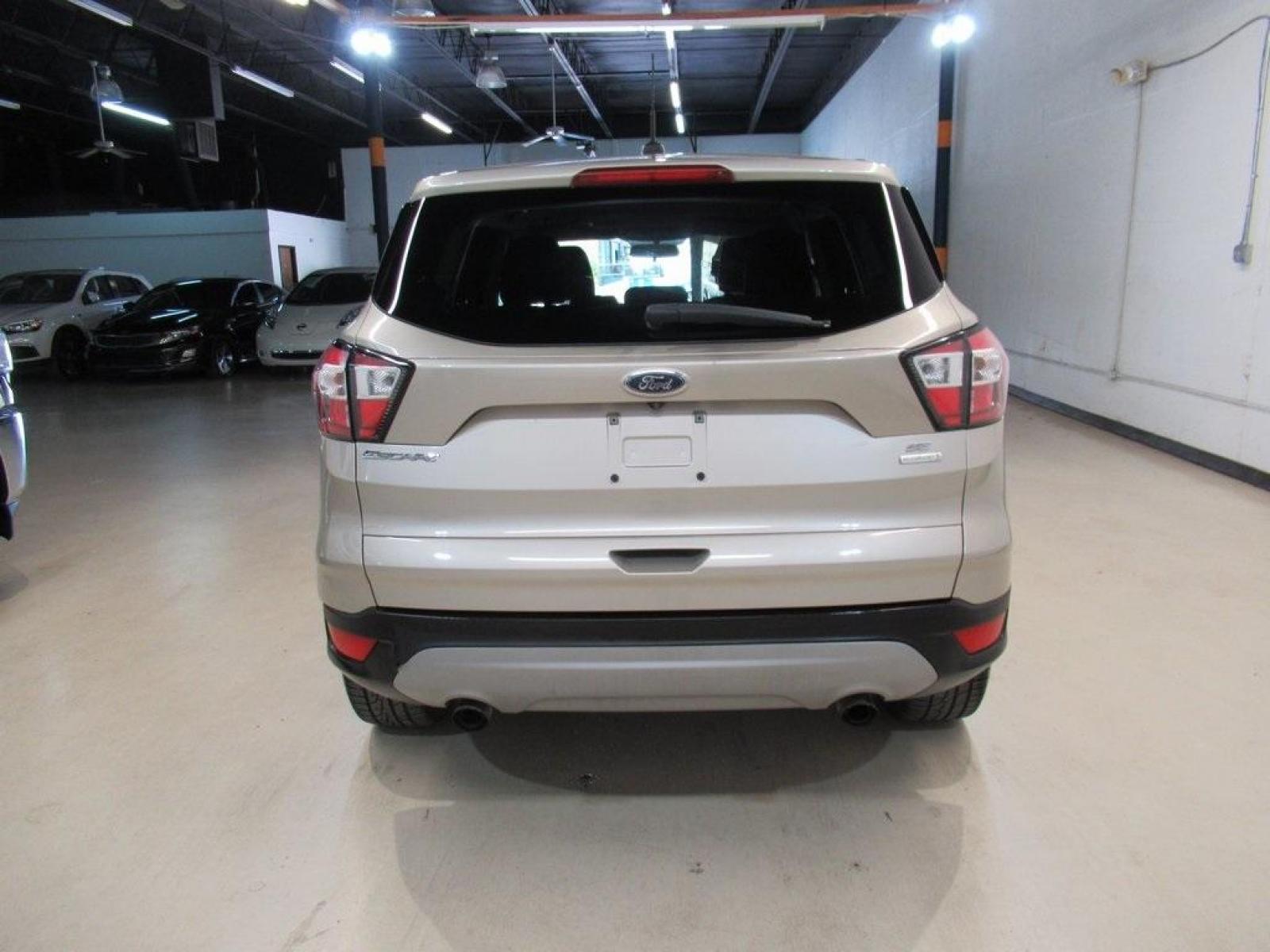 2017 White Gold Metallic /Charcoal Black Ford Escape SE (1FMCU0G94HU) with an EcoBoost 2.0L I4 GTDi DOHC Turbocharged VCT engine, Automatic transmission, located at 15300 Midway Rd., Addison, 75001, (972) 702-0011, 32.958321, -96.838074 - HOME OF THE NO HAGGLE PRICE - WHOLESALE PRICES TO THE PUBLIC!! Escape SE, 4D Sport Utility, EcoBoost 2.0L I4 GTDi DOHC Turbocharged VCT, 6-Speed Automatic, FWD, Gold, Charcoal Black Cloth.<br><br>Gold 2017 Ford Escape SE<br><br>Recent Arrival! 22/29 City/Highway MPG<br><br>Awards:<br> * 2017 KBB.co - Photo #7