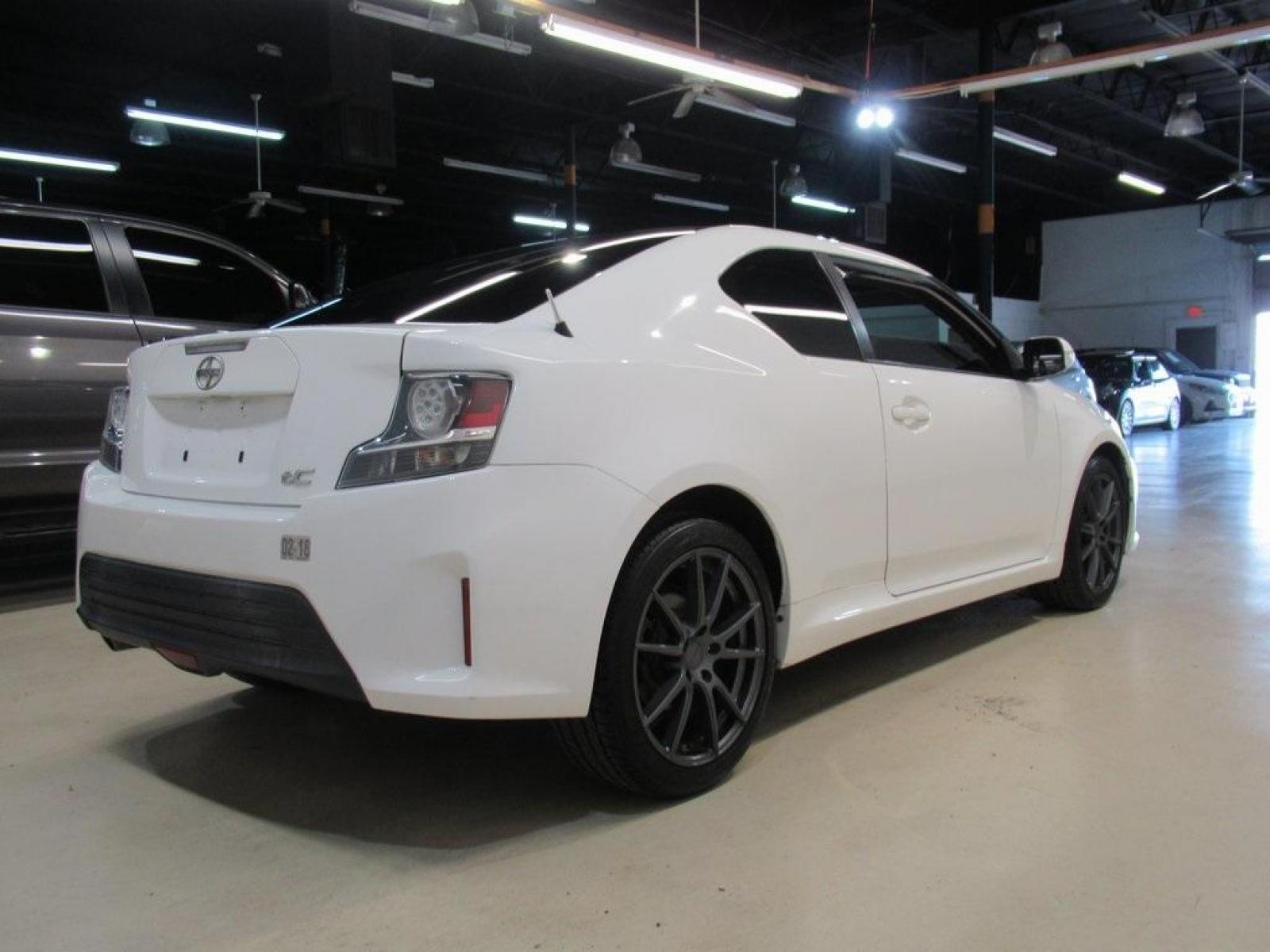 2014 Super White /Dark Charcoal Scion tC Base (JTKJF5C73E3) with an 2.5L I4 Dual VVT-i engine, Automatic transmission, located at 15300 Midway Rd., Addison, 75001, (972) 702-0011, 32.958321, -96.838074 - HOME OF THE NO HAGGLE PRICE - WHOLESALE PRICES TO THE PUBLIC!! 2D Coupe, 2.5L I4 Dual VVT-i, 6-Speed Automatic, FWD, Super White.<br><br>Super White 2014 Scion tC<br><br>23/31 City/Highway MPG<br><br>Awards:<br> * 2014 IIHS Top Safety Pick, Top Safety Pick, Top Safety Pick+<br><br>At Midway Auto Gr - Photo #2